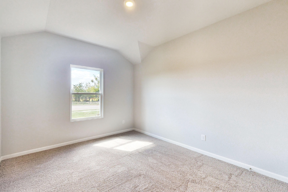 A room with a window and carpet.