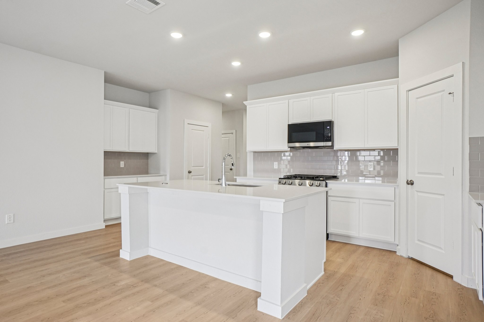 A kitchen with white cabinets.