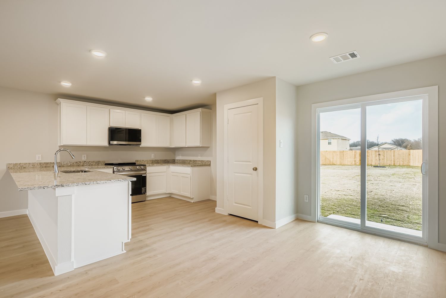 A kitchen with white cabinets.