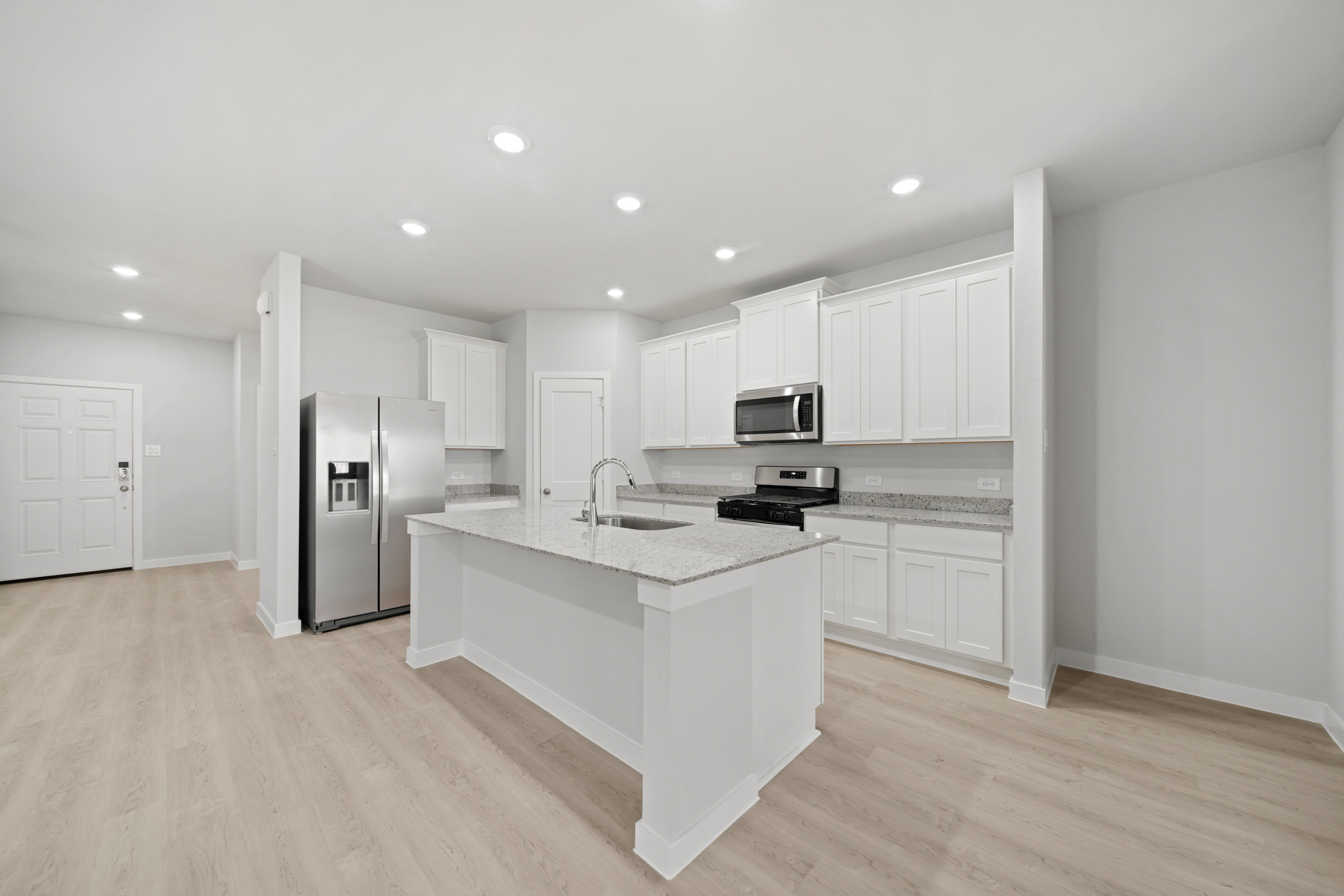A kitchen with white cabinets.