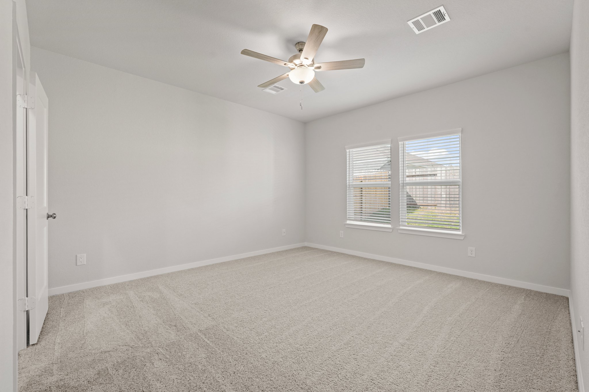 A room with a ceiling fan and a window.