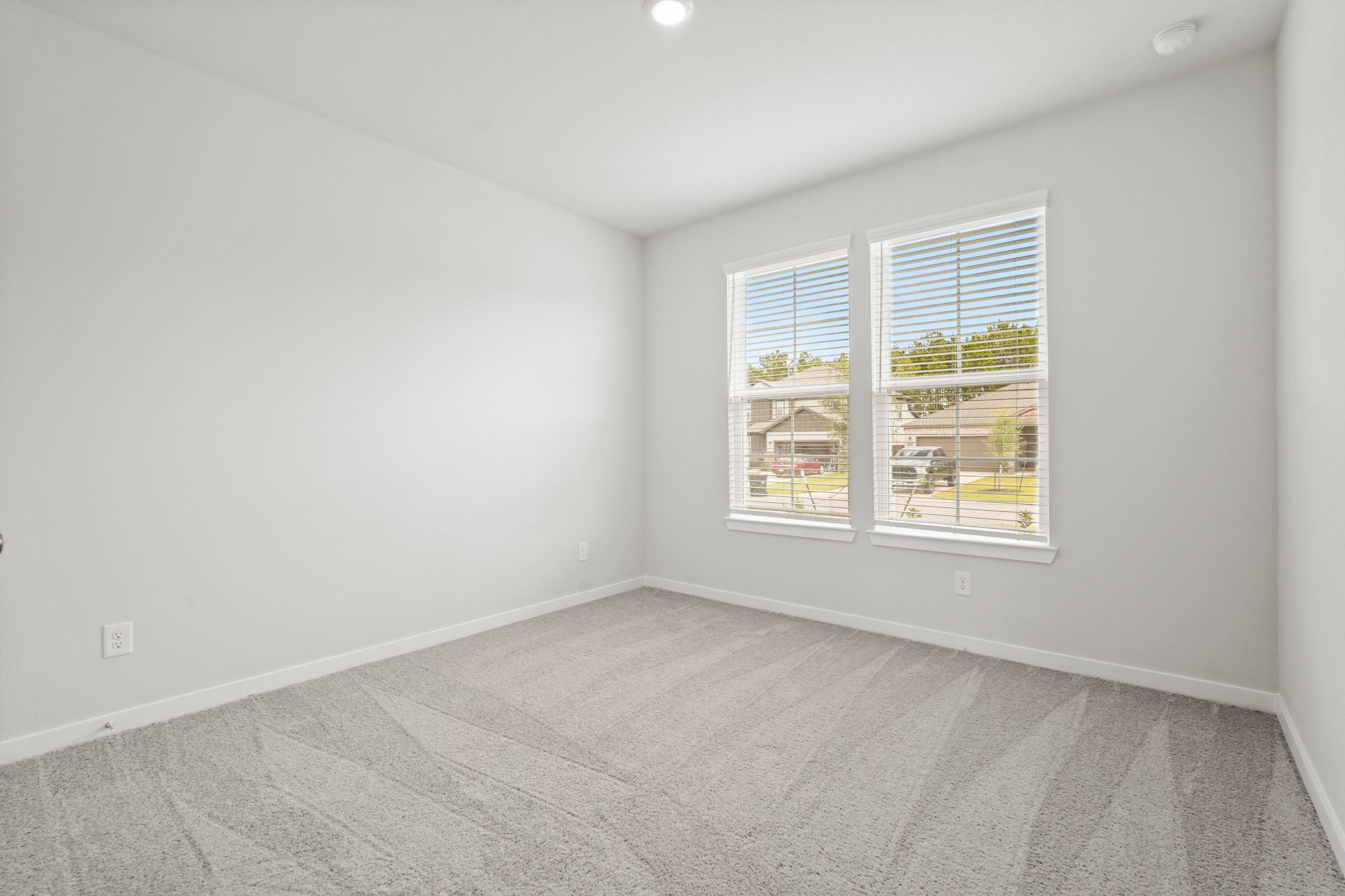 A room with a window and a carpet.
