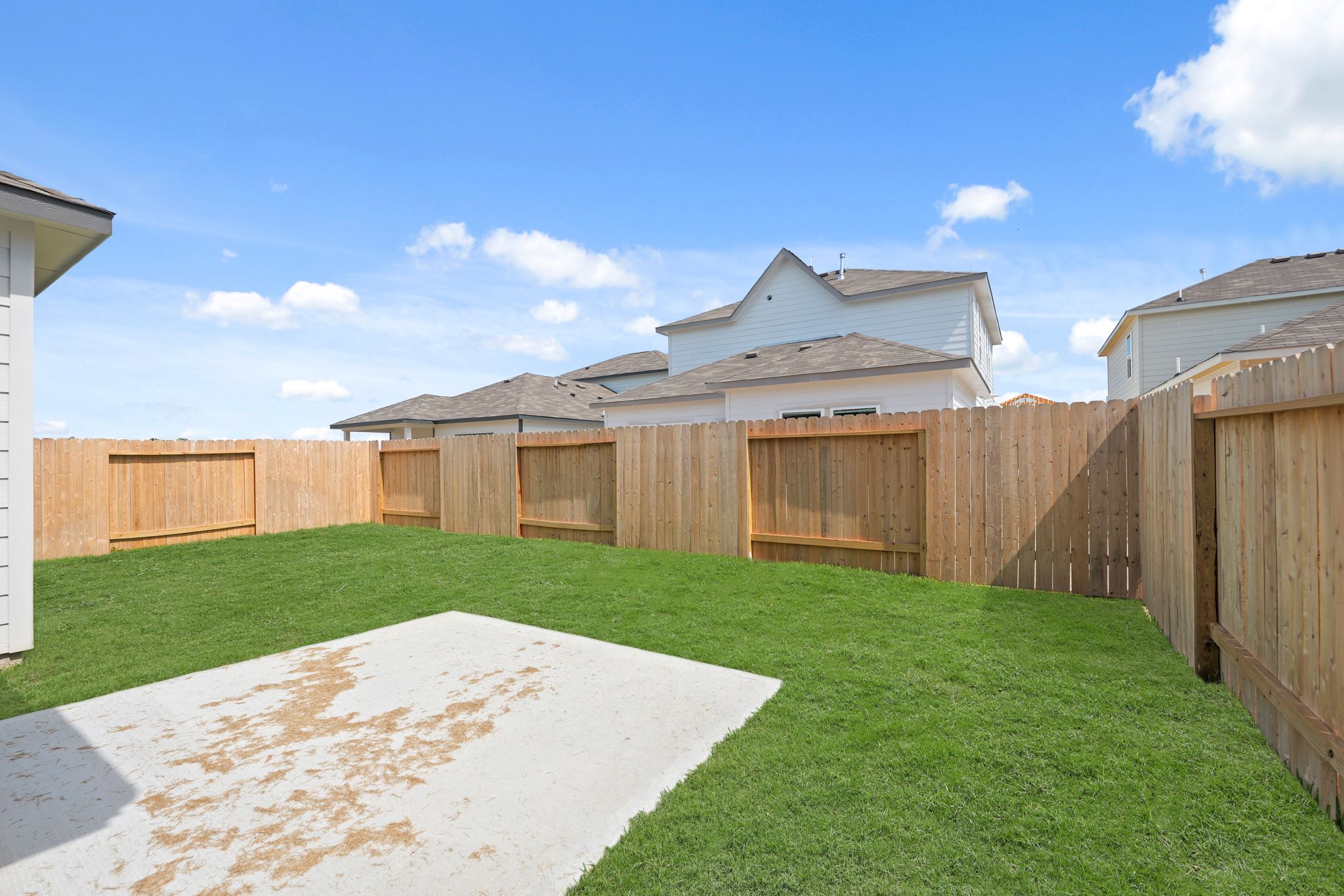 A fenced in yard with a house in the background.