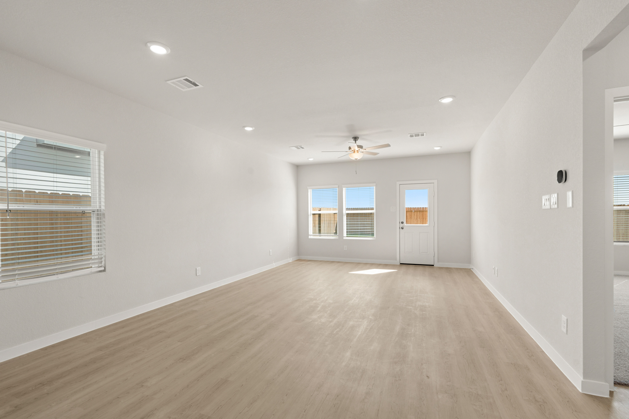 A room with a wood floor and a ceiling fan.
