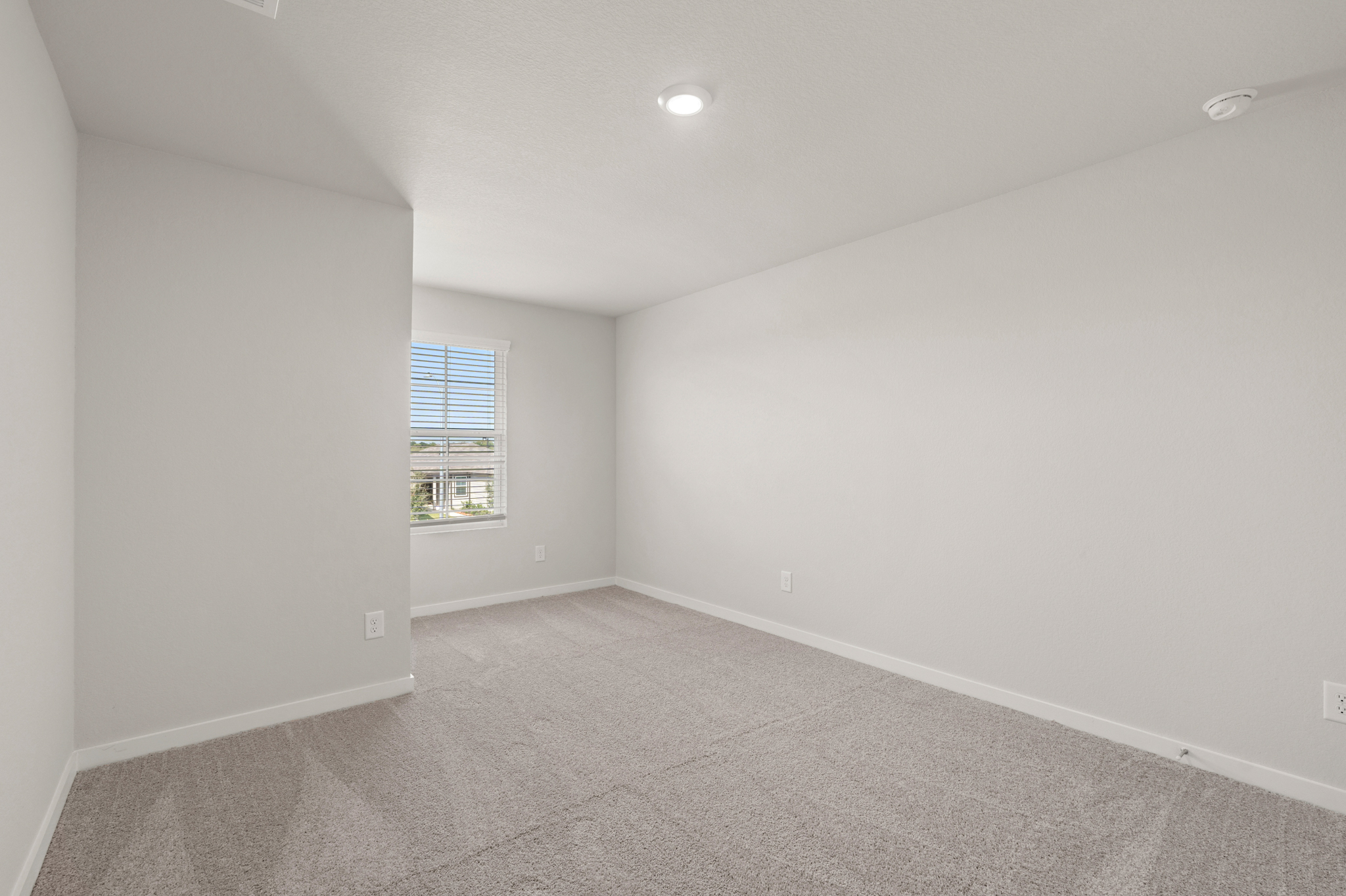 A room with a window and a carpet.