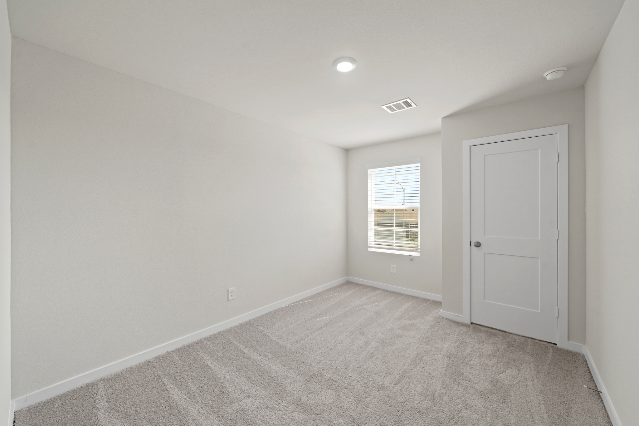 A room with white walls and a door.