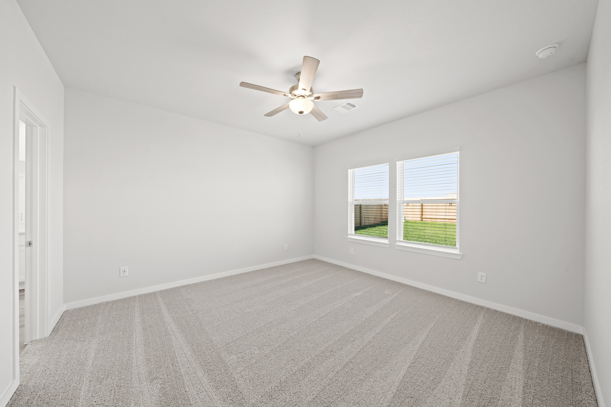 A room with a ceiling fan and a window.