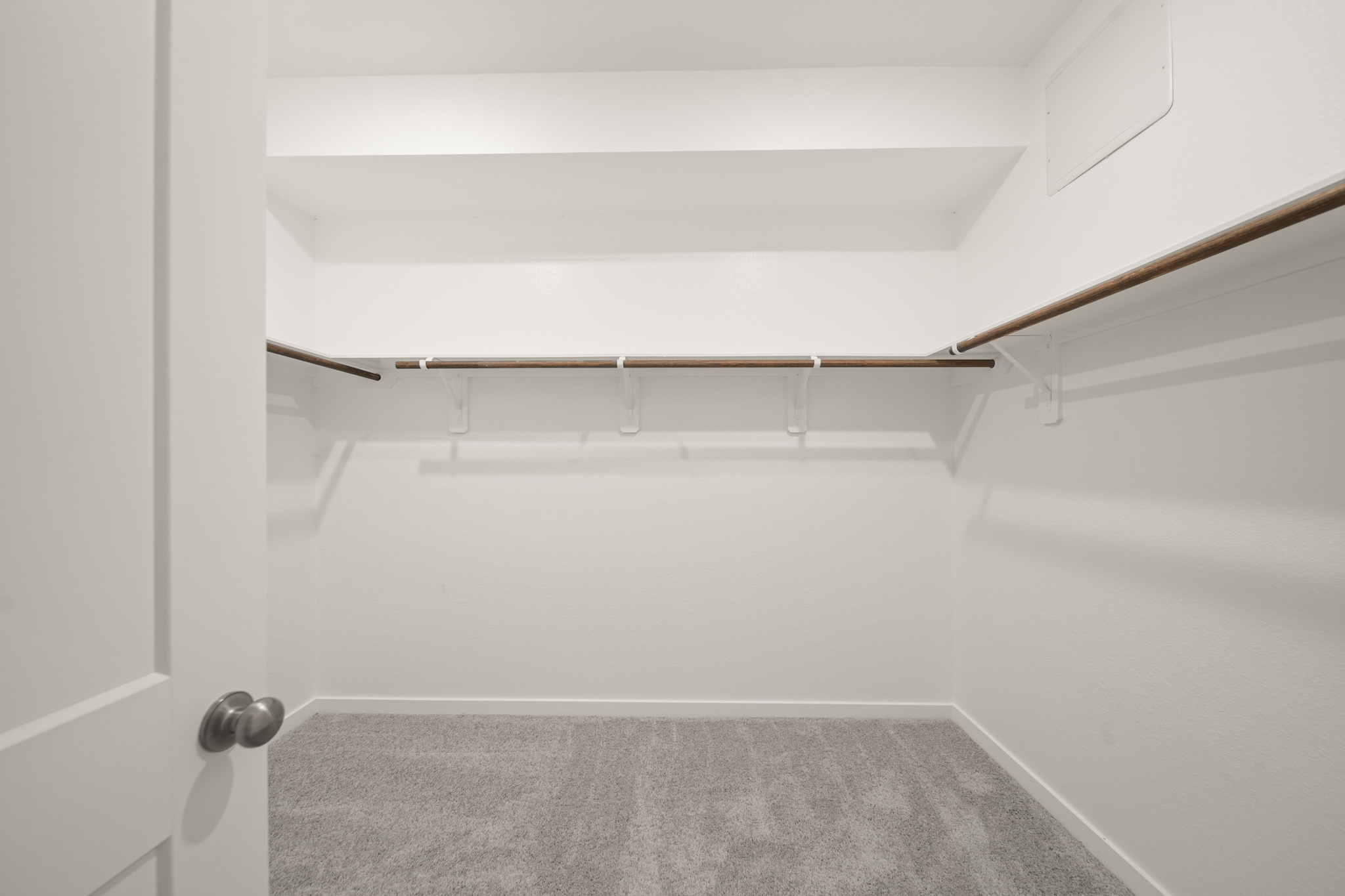 A white room with a grey carpet.