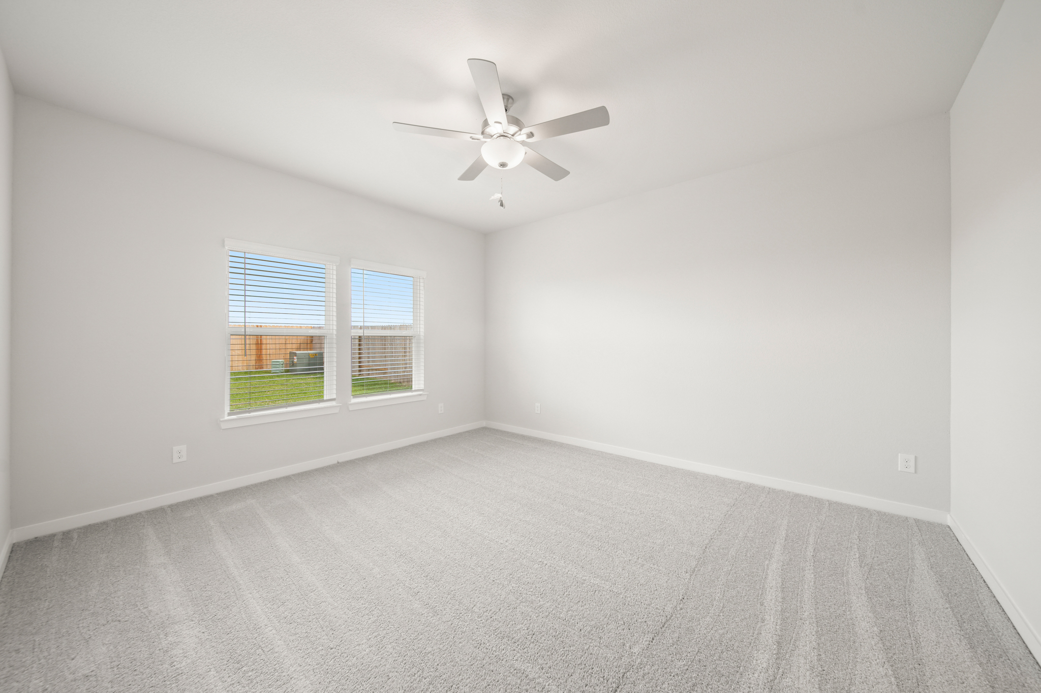 A room with a ceiling fan and a window.