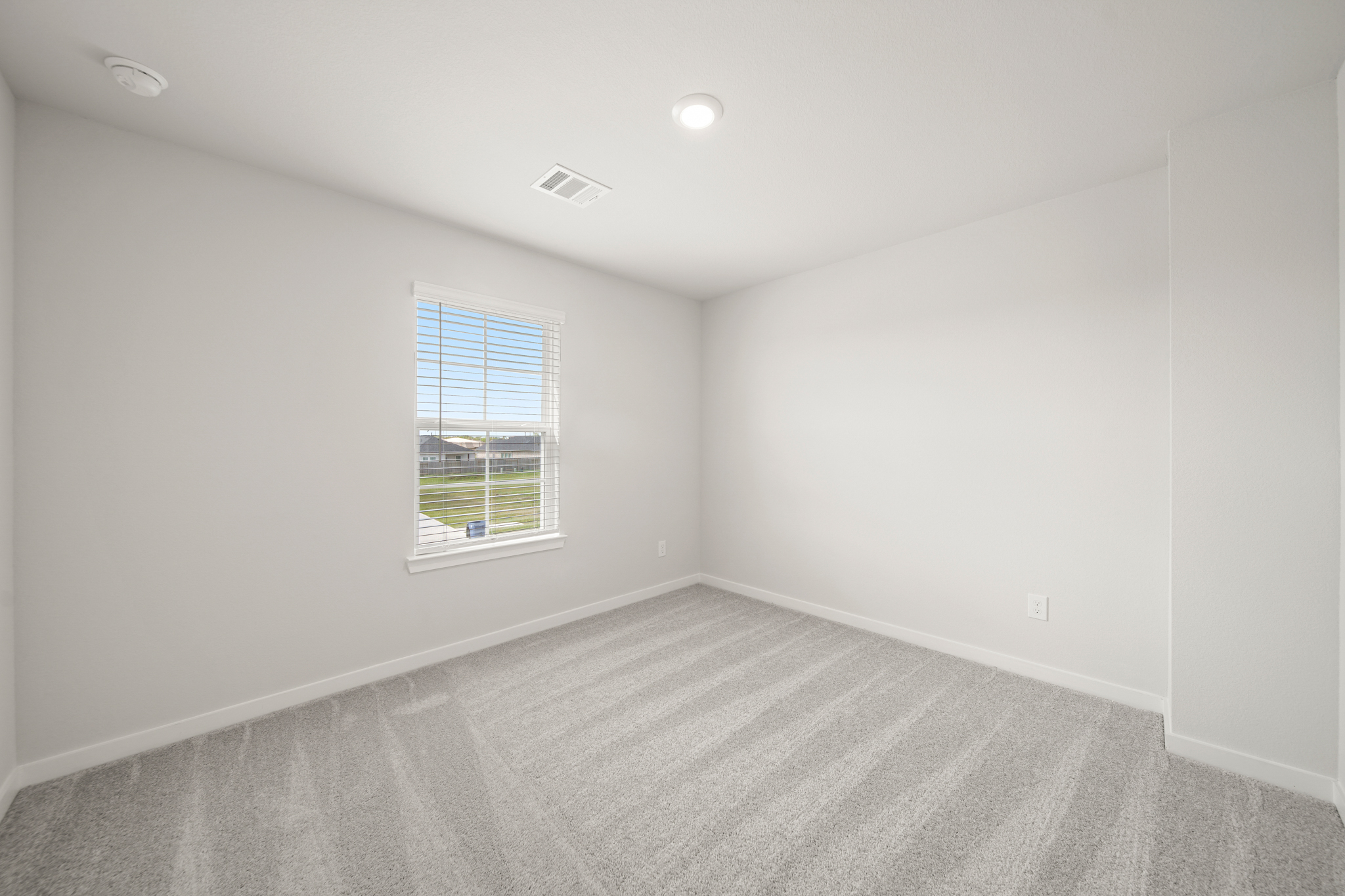 A room with a window and a carpet.