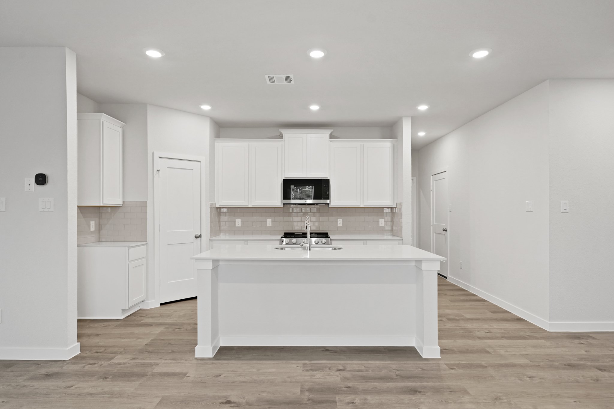 A kitchen with white cabinets.