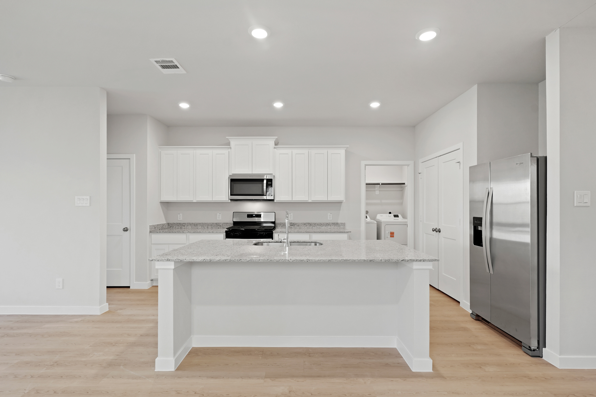 A kitchen with white cabinets.