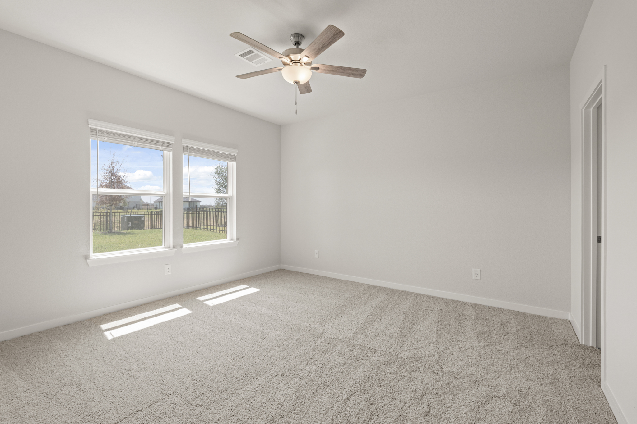 A room with a ceiling fan and a window.