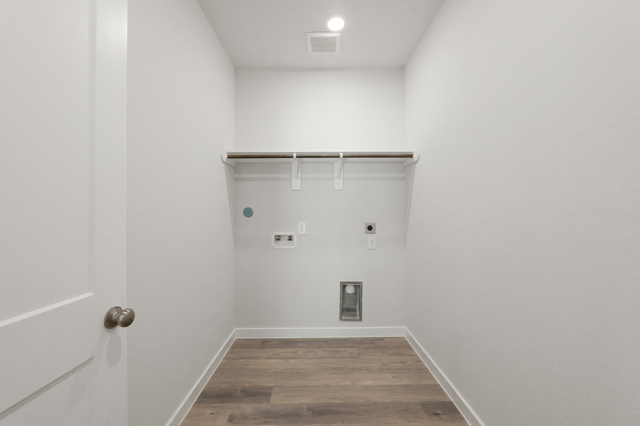 A room with a wood floor and white walls.