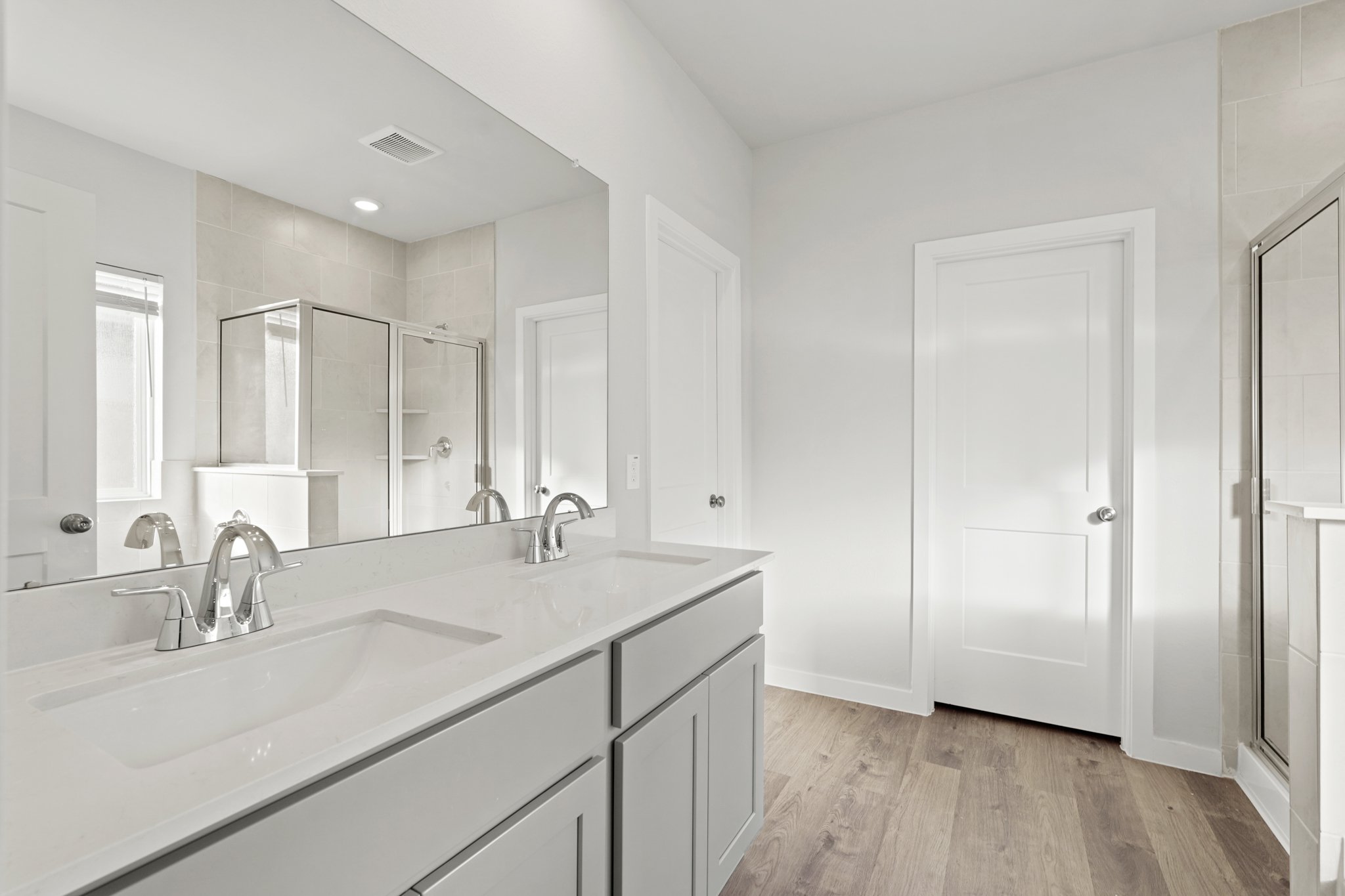 A bathroom with white cabinets.