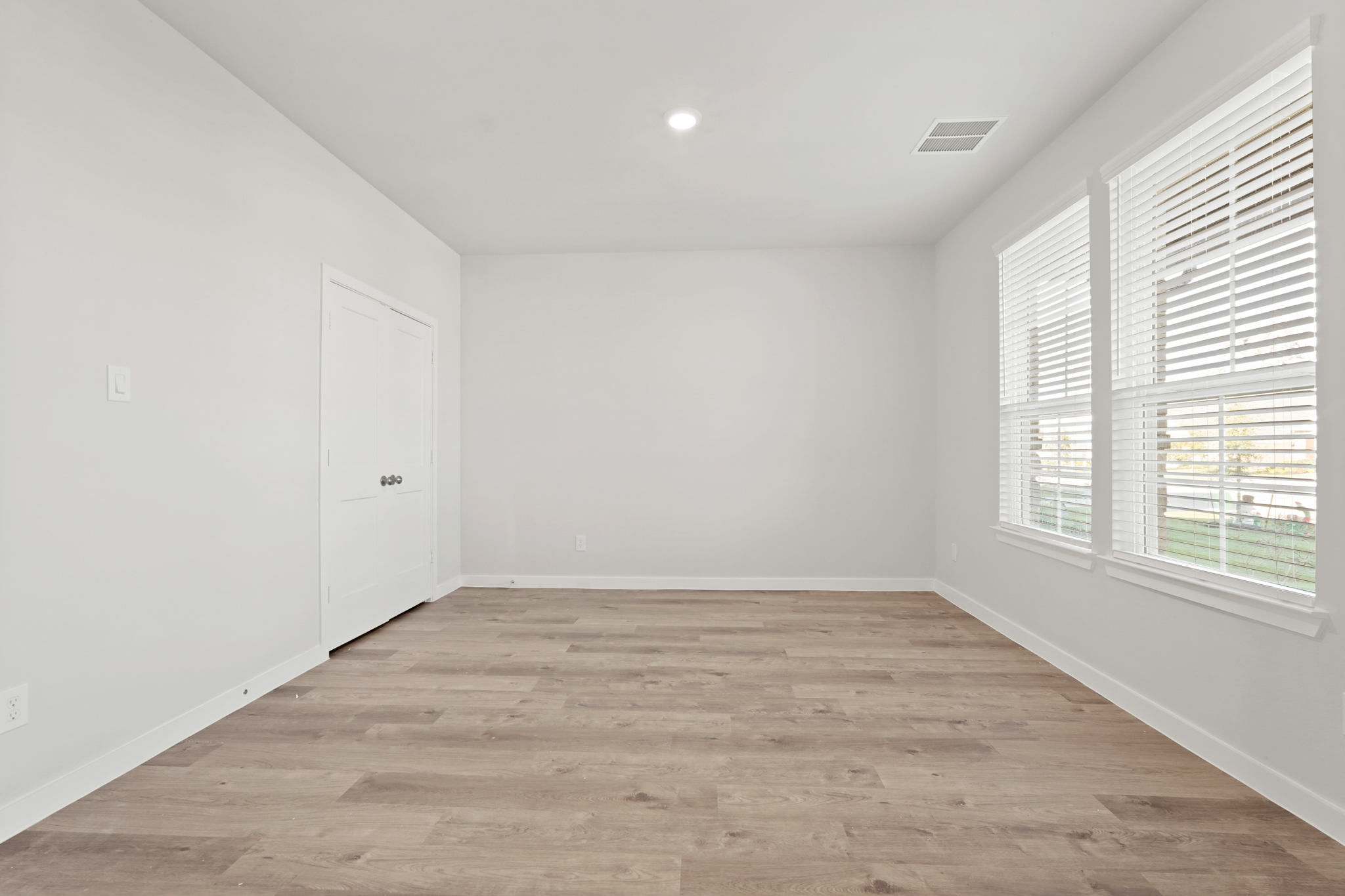 A room with a wood floor and white walls.