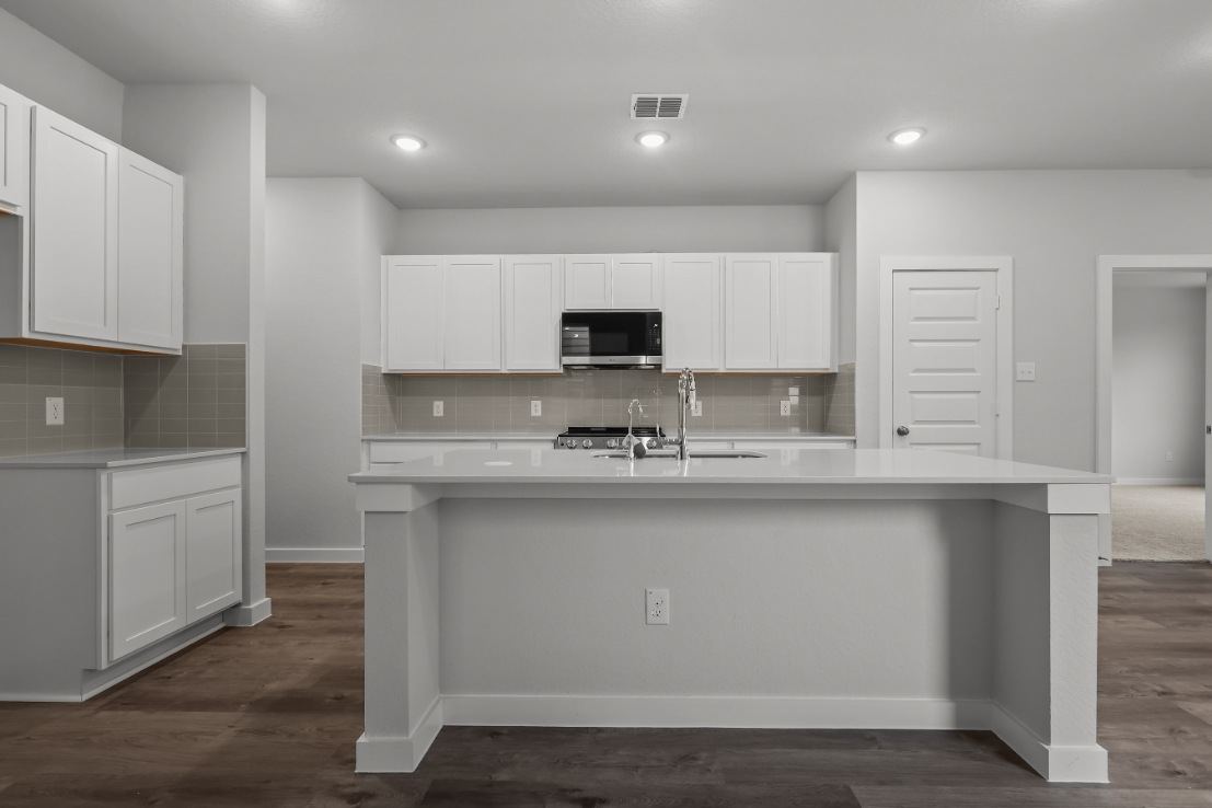 A kitchen with white cabinets.