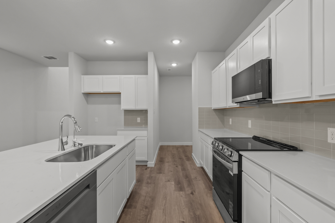 A kitchen with white cabinets.