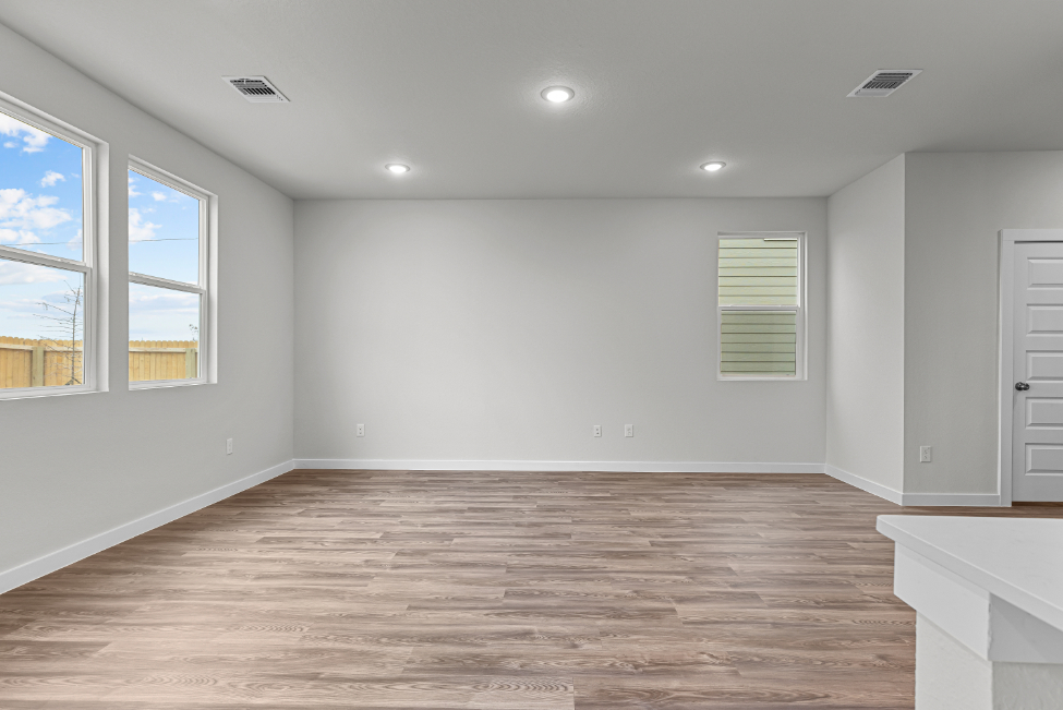 A room with a wood floor and windows.