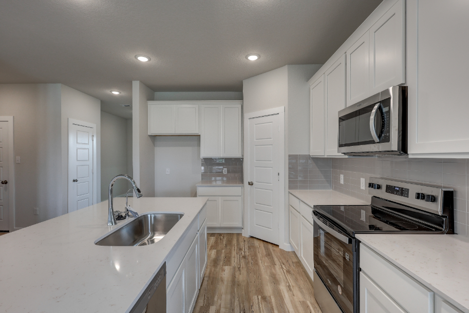 A kitchen with white cabinets.