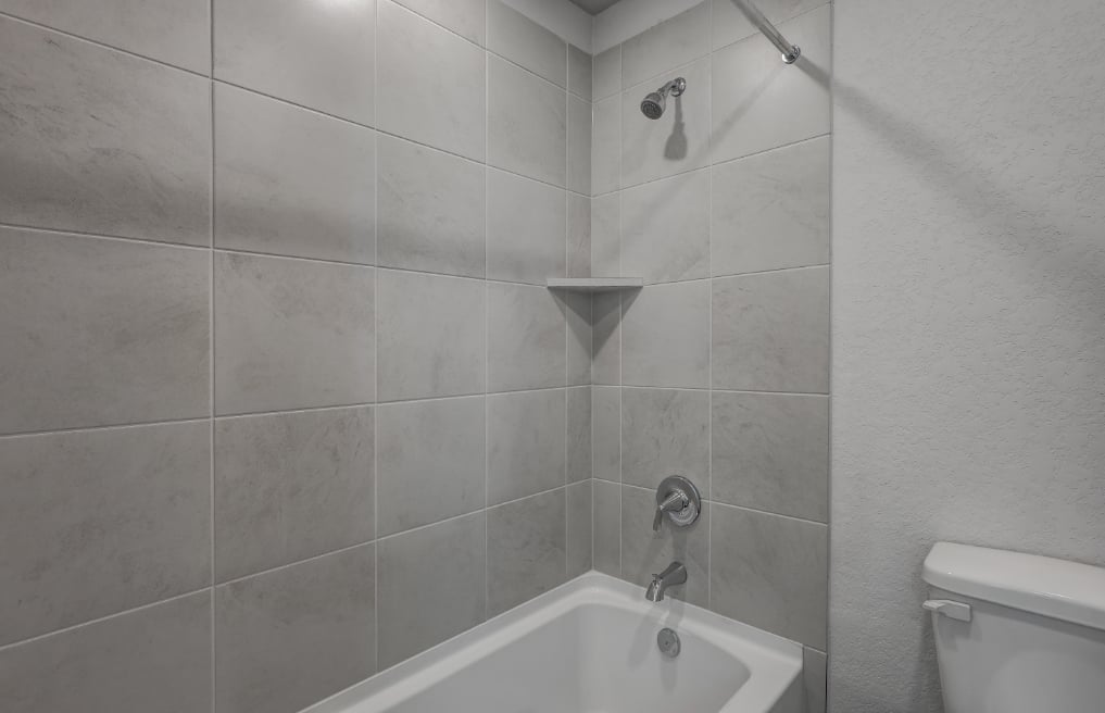 A bathroom with a bathtub and toilet.