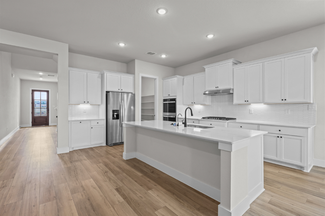 A kitchen with white cabinets.
