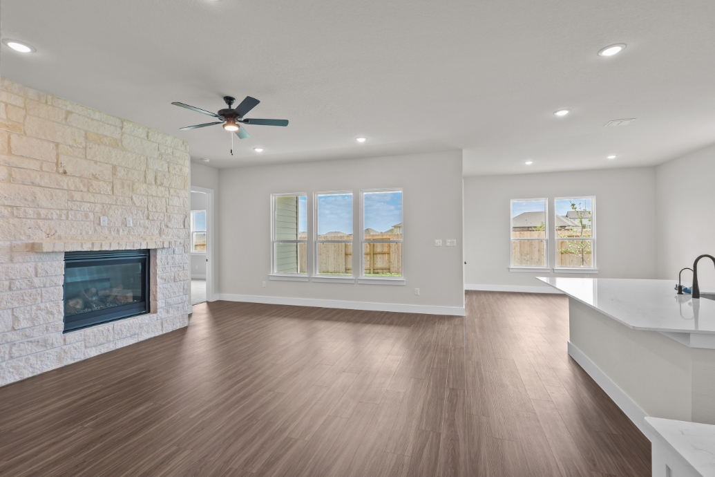 A large room with a fireplace and a wood floor.