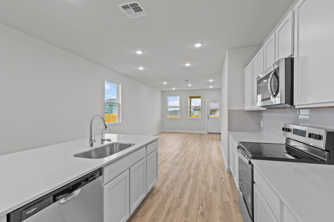 A kitchen with white cabinets.