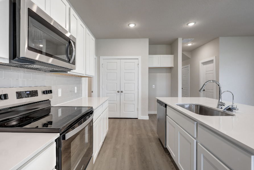 A kitchen with white cabinets.