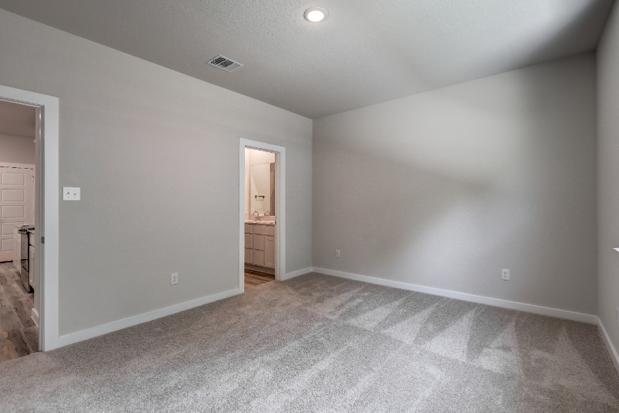 A room with a carpet and a door.