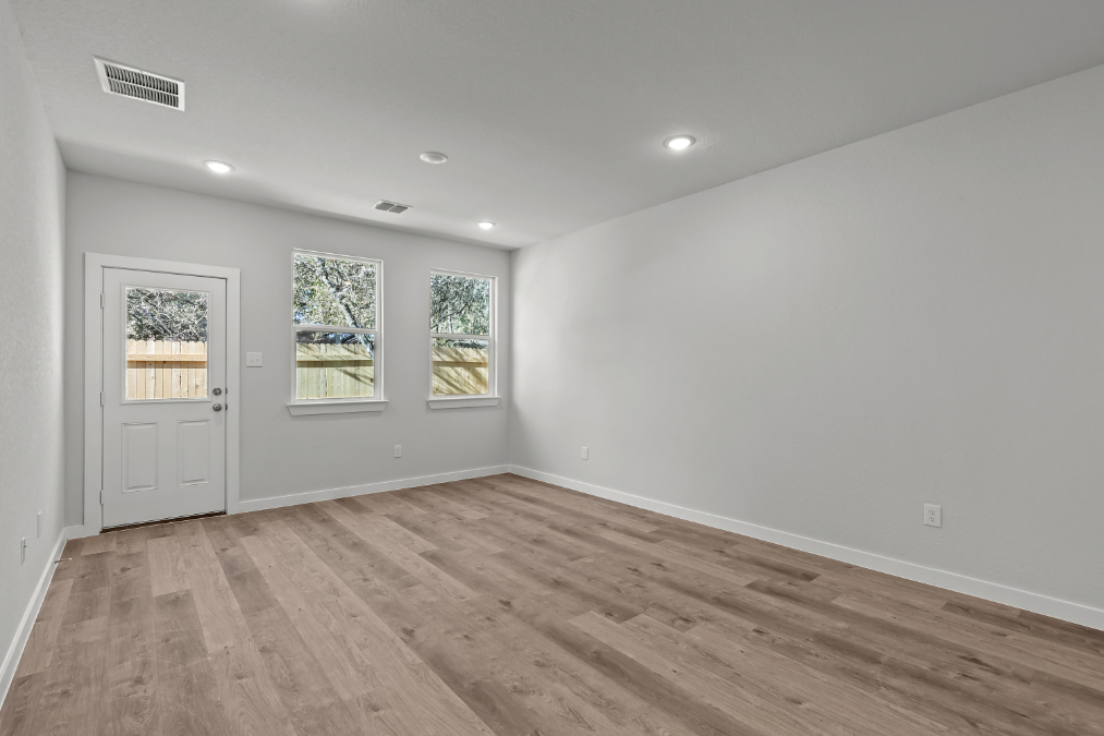 A room with a wood floor and a white door.