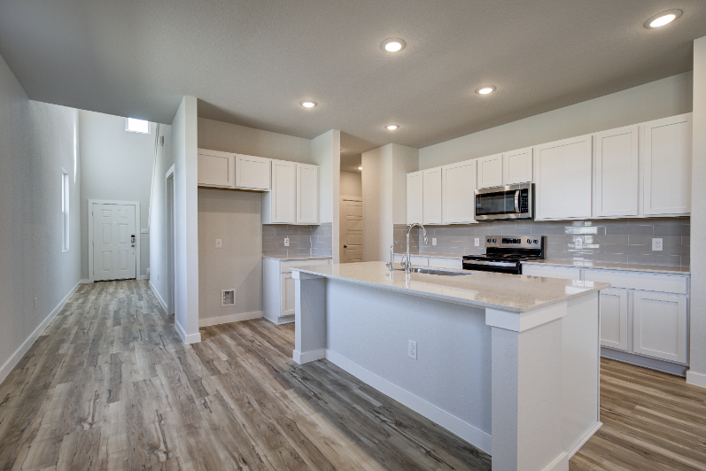 A kitchen with white cabinets.