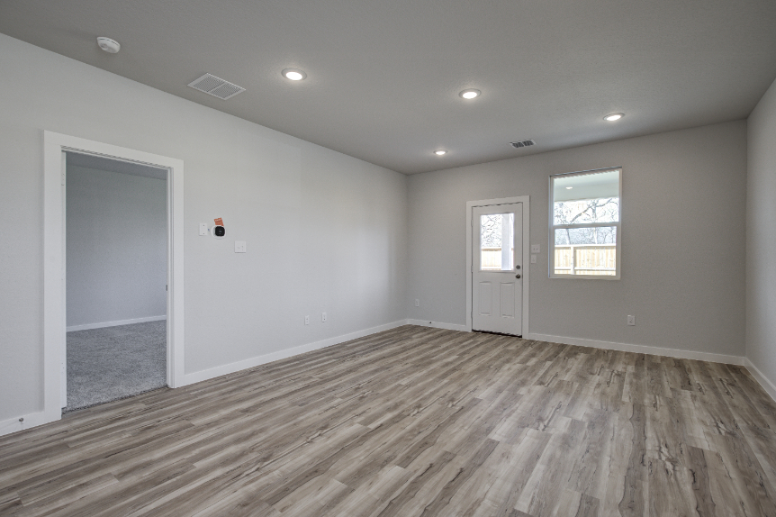 A room with a wood floor and white doors.