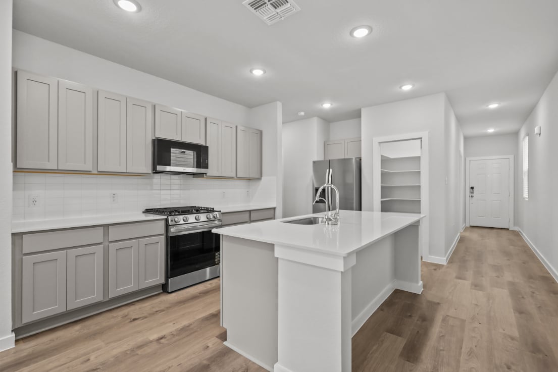 A kitchen with white cabinets.