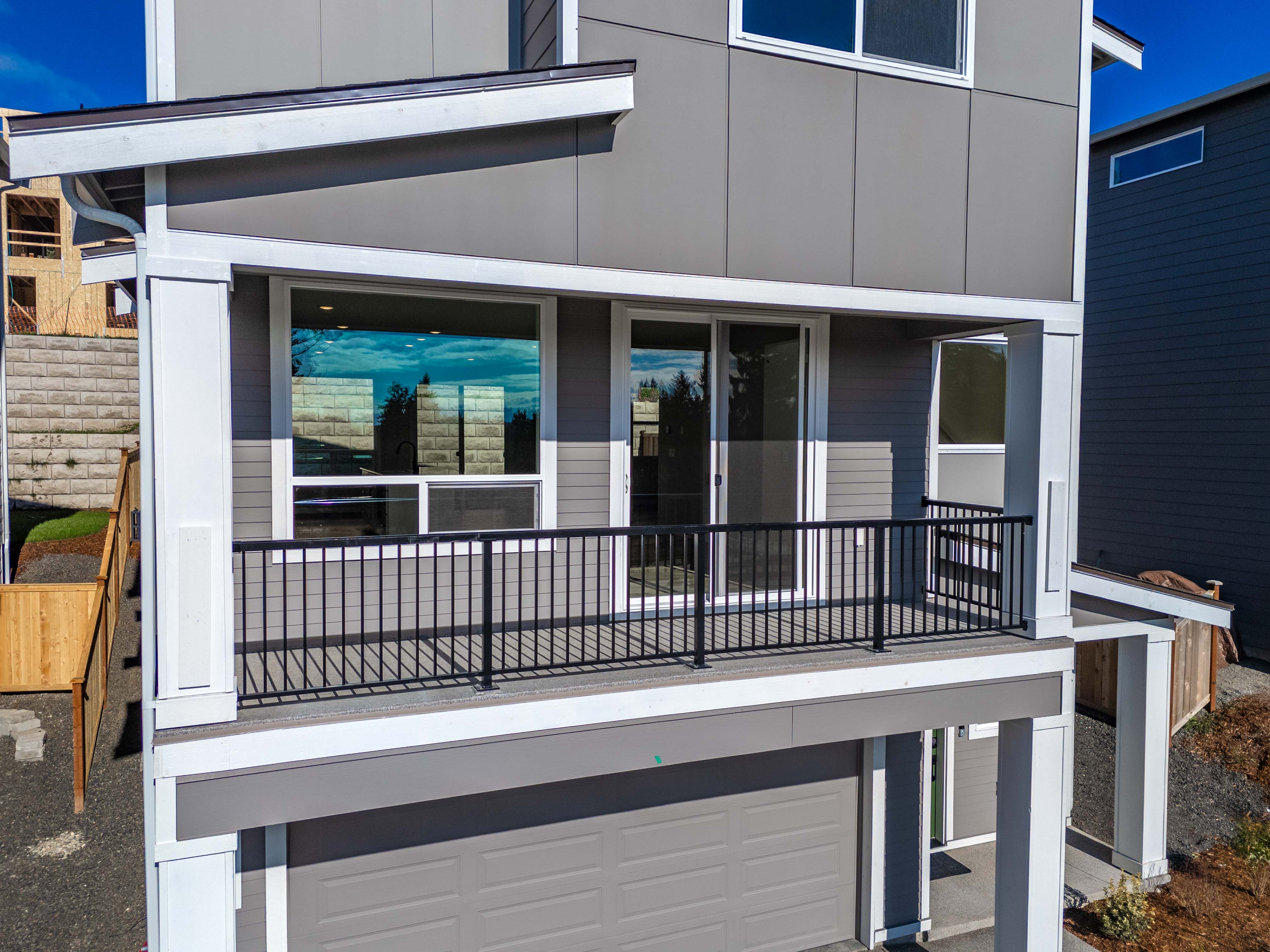 A white house with a black railing.