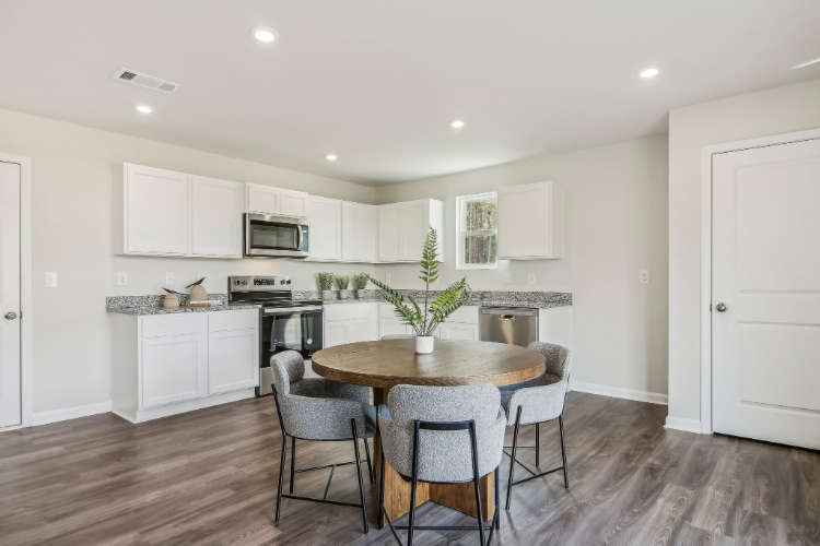 A kitchen with a table and chairs.