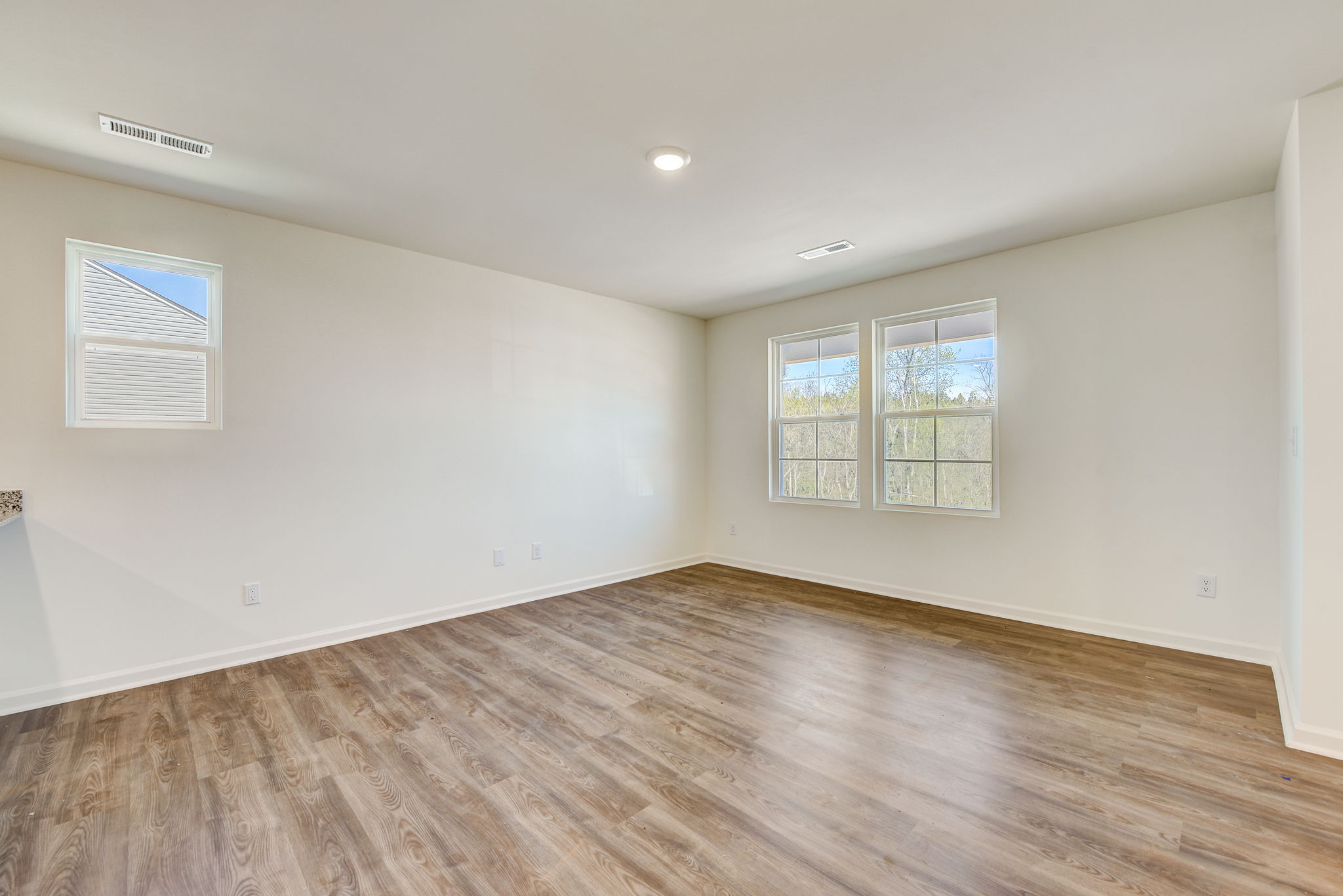 A room with a wood floor and windows.
