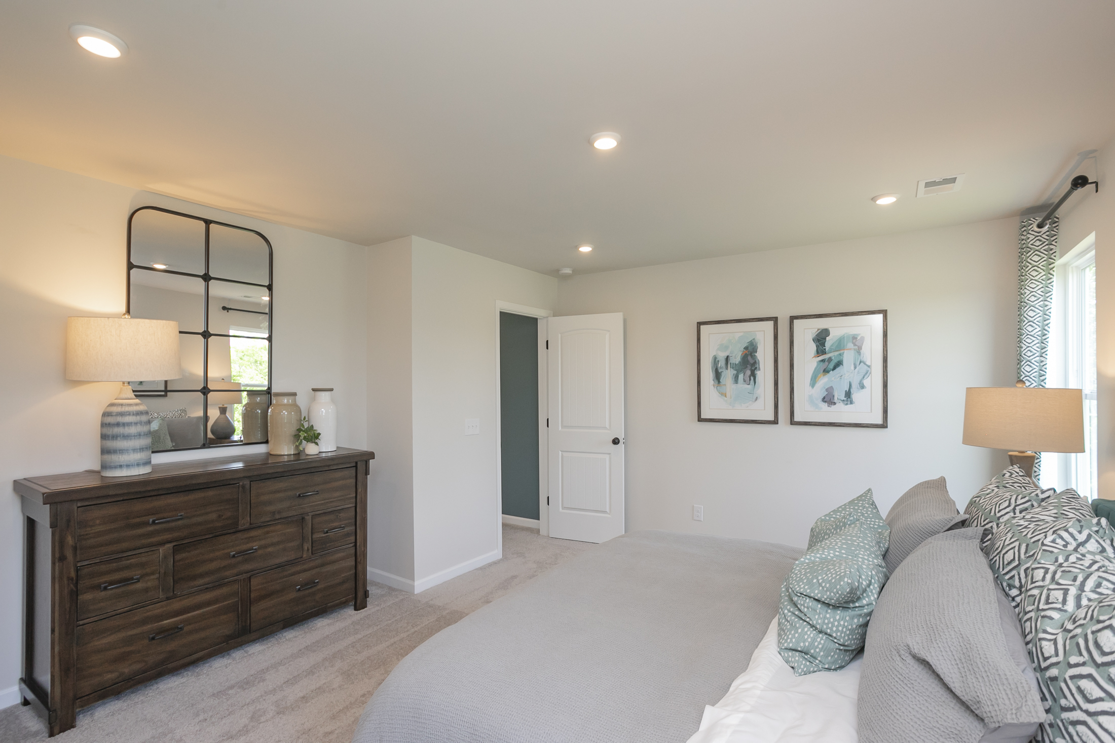 A bedroom with a bed and a dresser.