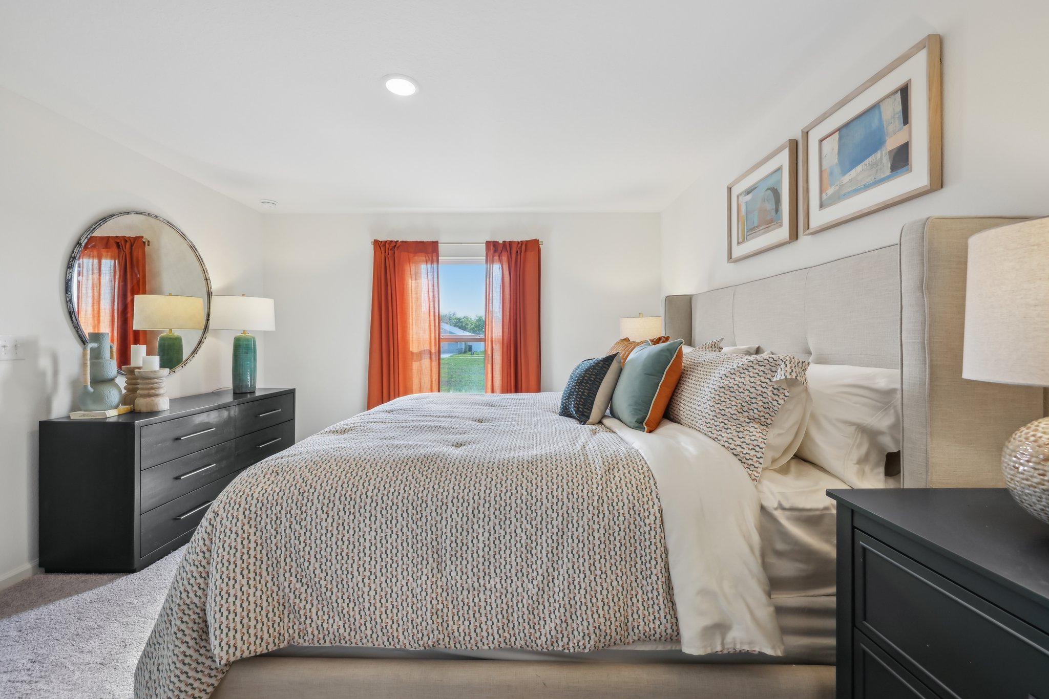 A bedroom with a bed and a mirror.