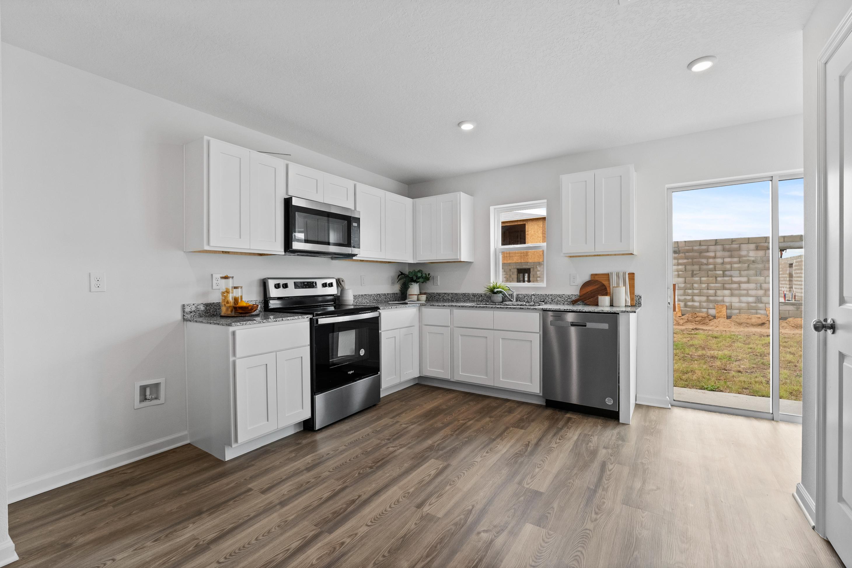 A kitchen with white cabinets.