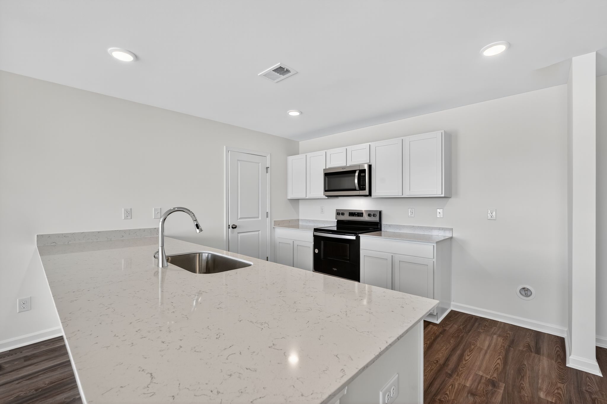 A kitchen with white cabinets.