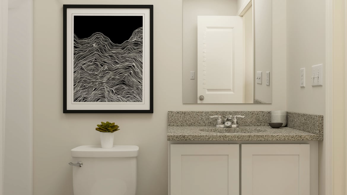 A bathroom with a picture on the wall.