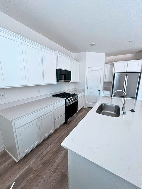 A kitchen with white cabinets.